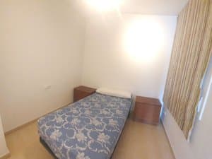 Dormitorio con cama y mesitas