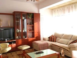 Salón con sofá, vitrina y televisor