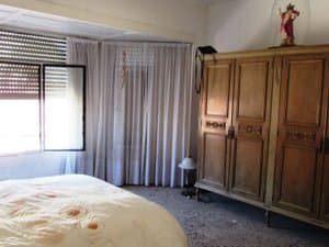 Dormitorio con armario de madera y mirador