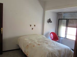 Dormitorio con cama y silla roja
