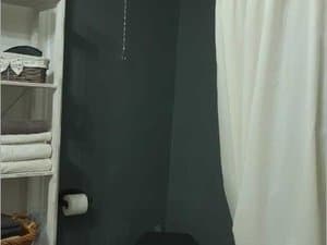 Baño con estantería y cortina