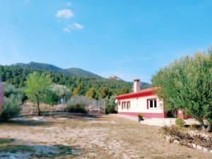 Chalet entre olivos con la sierra detrás