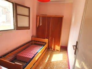 Dormitorio con cama y armario de madera