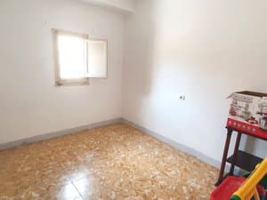 Dormitorio vacío con ventana pequeña