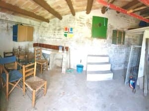 Interior de la caseta con techo de vigas y sillas