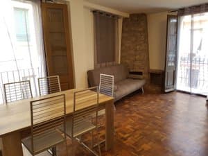 Comedor con mesa, sofá y salida al balcón