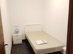 Dormitorio con cama de forja y mesita