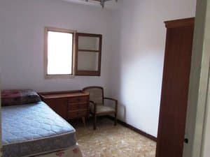 Dormitorio con cama, cómoda y butaca