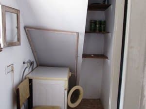 Rincón con lavadora bajo la escalera