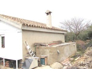Lateral de la casa con cisterna de obra