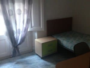 Dormitorio con cama y cortinas