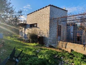 Casa de piedra con pérgola metálica