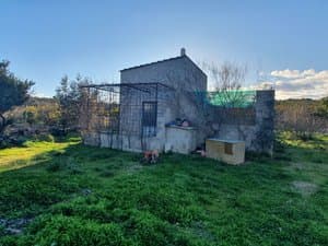 Casa de piedra con césped delante