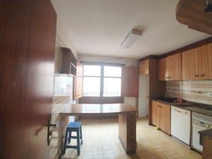 Cocina vista desde la puerta, con barra y taburete