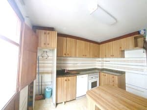 Cocina con encimera de madera y muebles altos