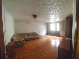 Salón con sofá rinconera y techo decorado