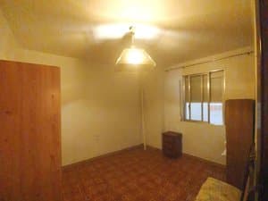 Dormitorio con armario y ventana