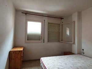 Dormitorio con cama y dos ventanas