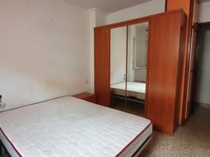 Dormitorio con cama y armario de puertas de espejo