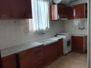 Cocina con muebles de madera, fregadero y cocina blanca