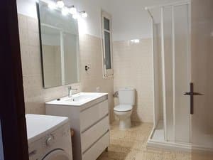 Baño con mueble de lavabo, lavadora y ducha