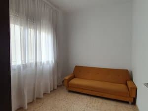 Estancia con sofá y ventana con cortinas
