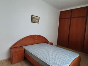Dormitorio con cama de matrimonio y mesita