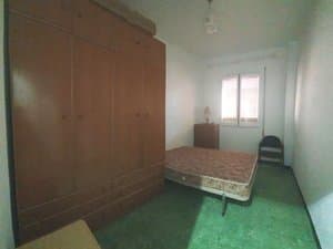Dormitorio con armario de madera y cama