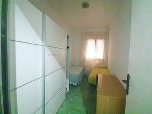 Dormitorio con armario de puertas correderas blancas