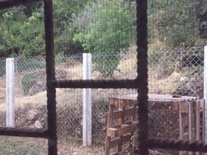 Vista del terreno cercado desde una ventana con reja