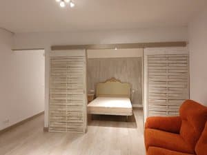 Zona de dormitorio separada por paneles de madera