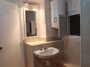 Baño con lavabo, espejo y termo