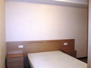 Dormitorio con cama y cabecero de madera