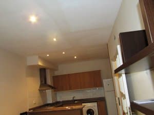 Cocina con campana, lavadora y estante