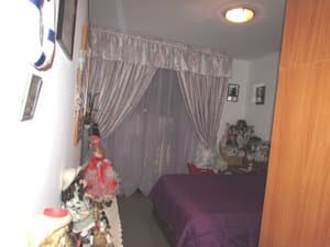 Dormitorio con cama y cortinas