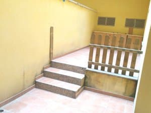 Patio exterior con escalera y barandilla de madera