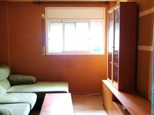 Salón con sofá, mesa baja y mueble vitrina