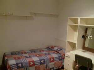 Dormitorio con cama individual y escritorio