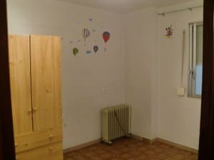 Dormitorio con armario de madera y radiador