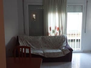 Salón con sofá y puerta al balcón