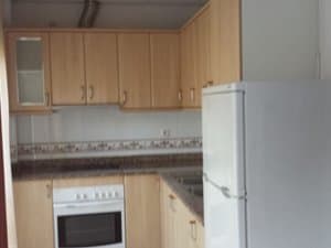 Cocina con muebles de madera, horno y frigorífico