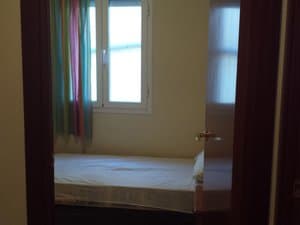 Dormitorio con cama y ventana con cortinas