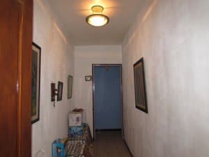 Pasillo con cuadros y puerta al fondo
