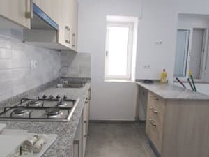 Cocina con placa de gas, fregadero y ventana