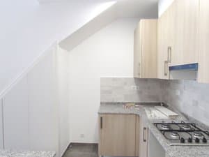 Cocina con muebles nuevos junto a la escalera