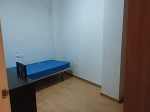 Dormitorio con cama individual y escritorio