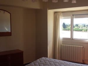 Dormitorio con cómoda, espejo y radiador