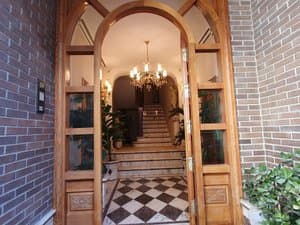 Entrada con puertas de madera y suelo ajedrezado