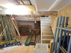 Planta baja con escalera y materiales almacenados