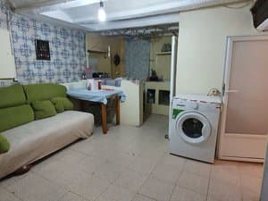 Cocina comedor con sofá, mesa y lavadora